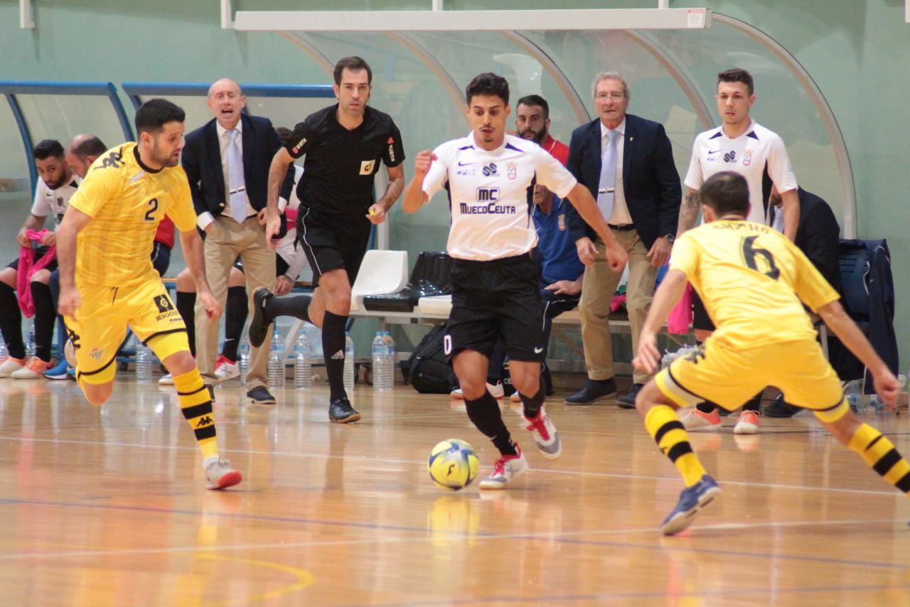 Anuar, del UA Ceutí, conduce el balón ante Burrito y Chicho, jugadores del Real Betis Futsal