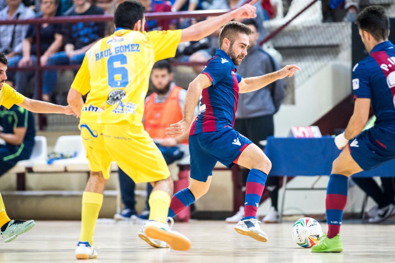 Cecilio, del Levante UD FS, conduce el balón ante Raul Gómez, del Servigroup Peñíscola