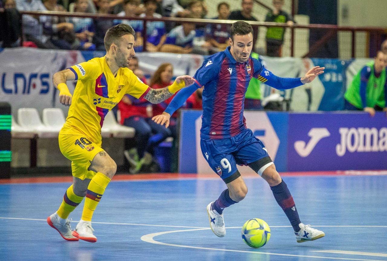 Márquez, del Levante UD FS, conduce el balón ante la presencia de Rivillos, del Barça