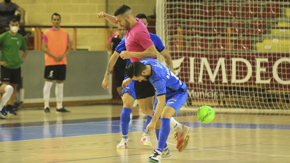 Saura, de Córdoba Patrimonio, pelea el balón ante dos rivales.