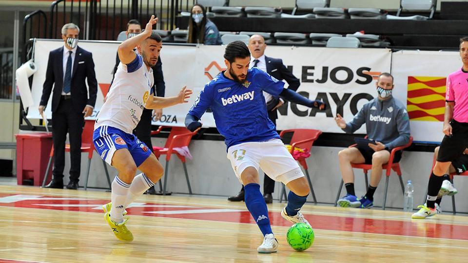 Emilio Buendía, de Real Betis, con el balón ante la presión de Óscar Villanueva, de Fútbol Emotion Zaragoza.