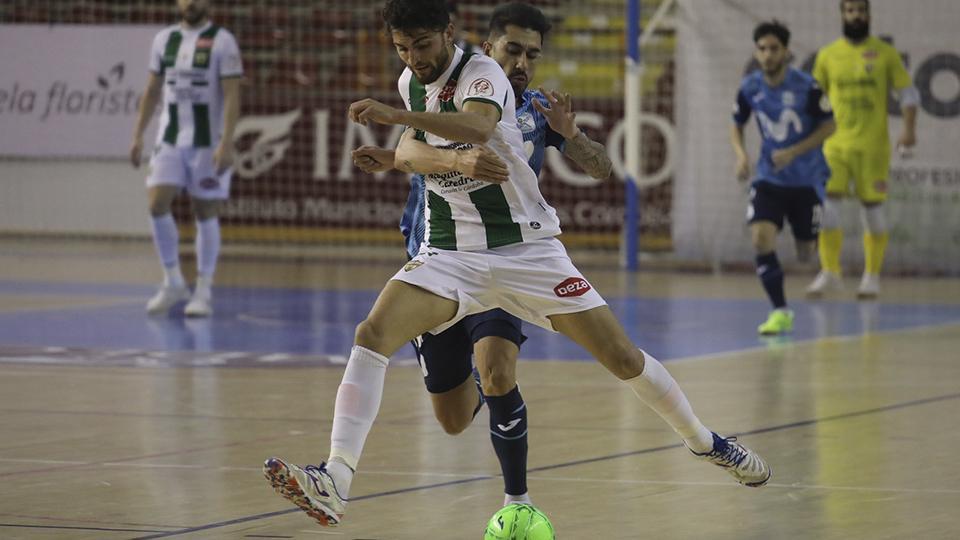 Zequi, de Córdoba Patrimonio, conduce el balón ante la presión de un rival.