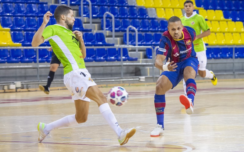 Ferrao, del Barça, golpea el balón ante la presencia de Raúl Campos, del Palma Futsal