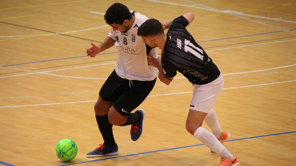 We Casas , jugador de la Unión África Ceutí, protege el balón ante Hugo, de Rivas Futsal.