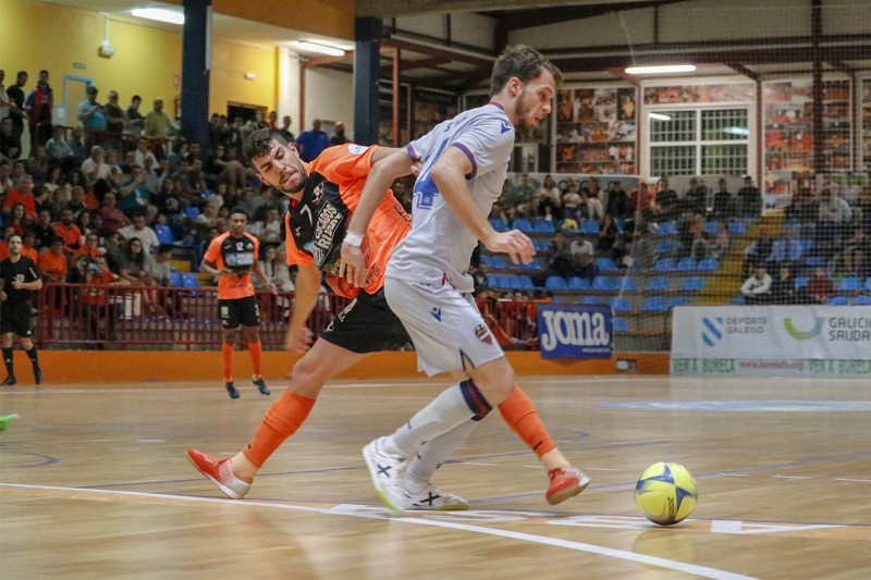 Los jugadores de ambos equipos se disputan el balón, durante un lance del juego. 
